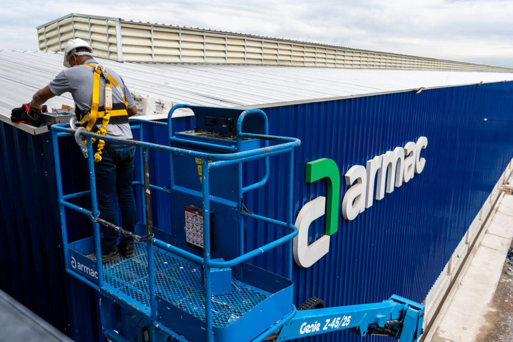 operador da armac em uma plataforma elevatória realizando uma manutenção em uma fachada da empresa armac