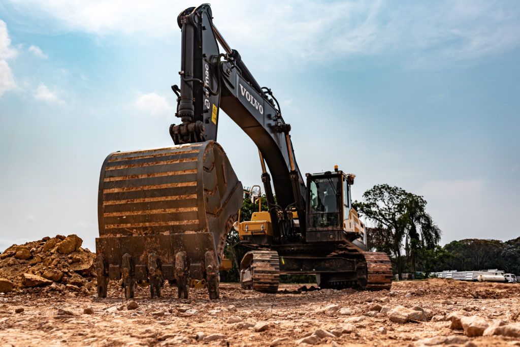 escavadeira volvo armac a céu aberto, num terreno com pedras, vis de frente