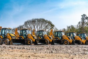 Retroescavadeiras JCB alinhadas e prontas para operação, ilustrando a disponibilidade imediata de máquinas pesadas seminovas para empresas que antecipam a renovação da frota em 2025.
